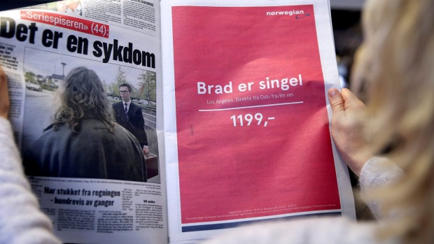 Жена во Осло држи весник со рекламата на Norwegian Airlines „Бред е Single”,  Лос Анџелес, Директно лет во еден правец,  1199,- ..."
Извор на фотографија: http://www.stuff.co.nz/